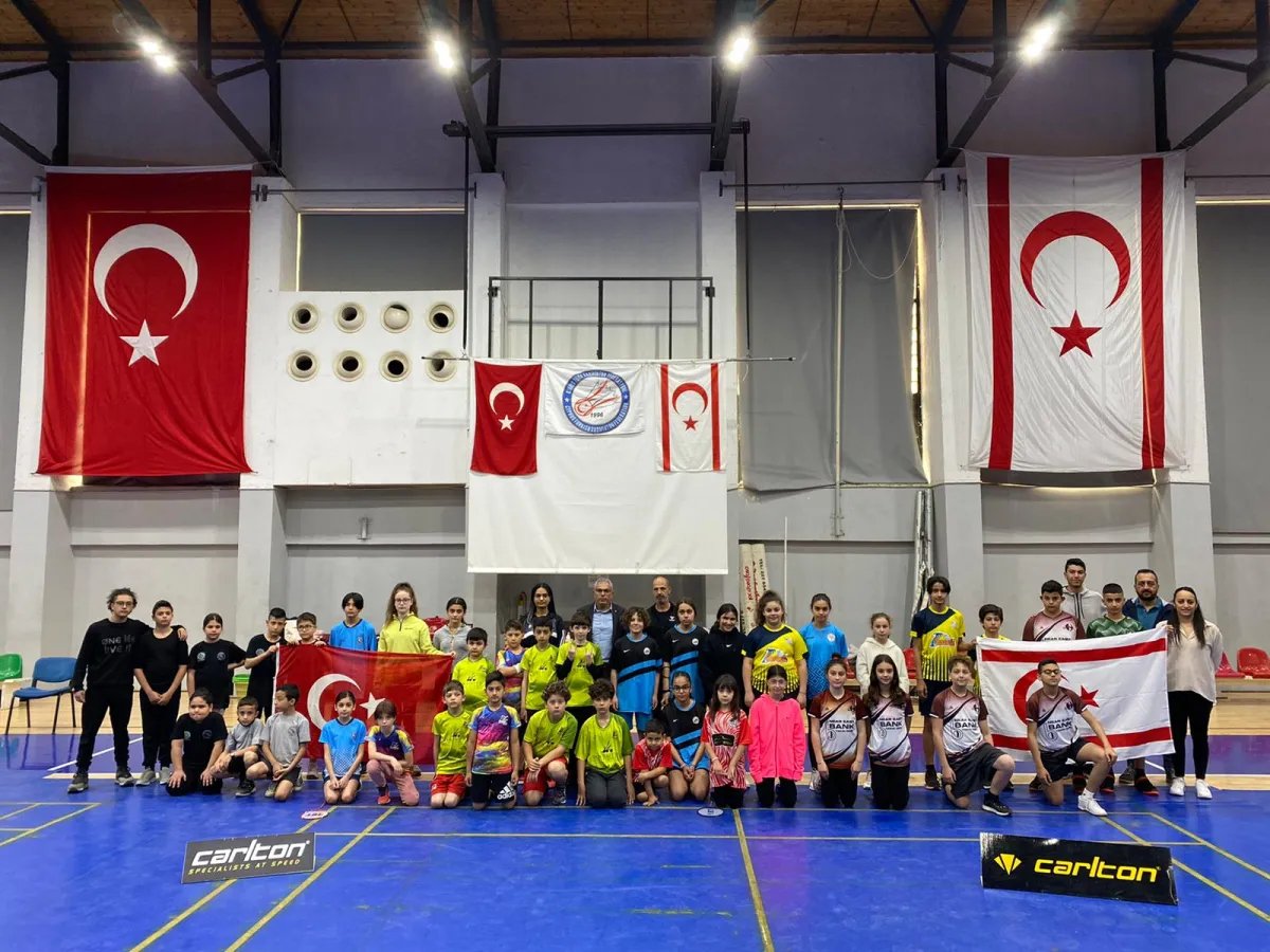 23 Nisan U13 Open turnuvasına katılan çocuklar, aileleri ve antrenörleri bayraklar önünde toplu fotoğrafta